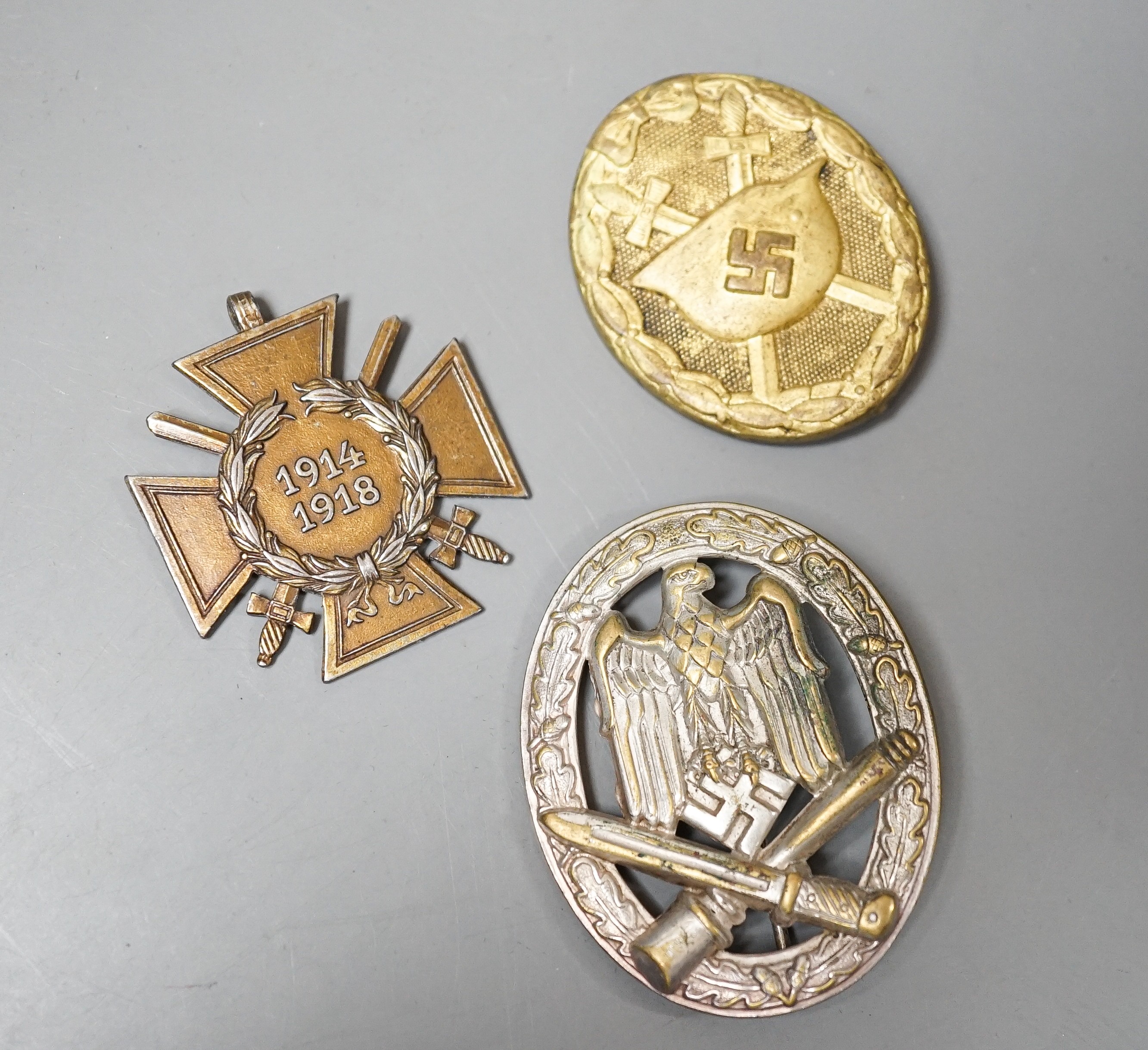 A WW2 German Army / Waffen-SS General Assault Combat Badge in Silvered brass and a Third Reich Wound Badge in Gilt, together with a WW1 German 1914-1918 cross (3)